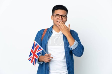 Foto de Joven ecuatoriana sosteniendo una bandera del Reino Unido aislada sobre fondo blanco feliz y sonriente cubriendo boca con mano - Imagen libre de derechos