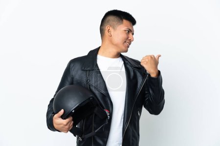 Foto de Hombre ecuatoriano con casco de moto aislado sobre fondo blanco apuntando hacia un lado para presentar un producto - Imagen libre de derechos