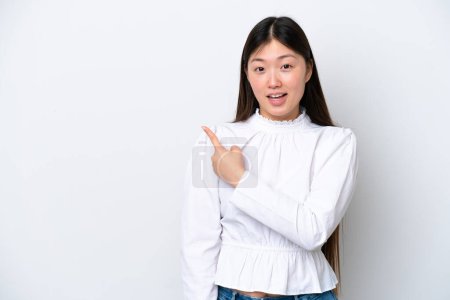 Téléchargez les photos : Jeune femme chinoise isolée sur fond blanc surpris et pointant côté - en image libre de droit