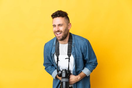 Photo for Photographer man isolated on yellow background smiling a lot - Royalty Free Image