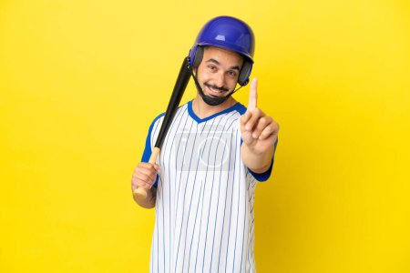 Photo for Young caucasian man playing baseball isolated on yellow background showing and lifting a finger - Royalty Free Image