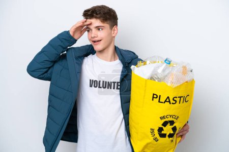 Foto de Adolescente rusa sosteniendo una bolsa llena de botellas de plástico para reciclar sobre fondo blanco sonriendo mucho - Imagen libre de derechos
