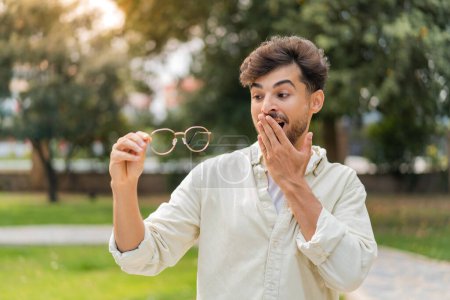 Photo for Young Arabian handsome man with glasses at outdoors with surprise and shocked facial expression - Royalty Free Image