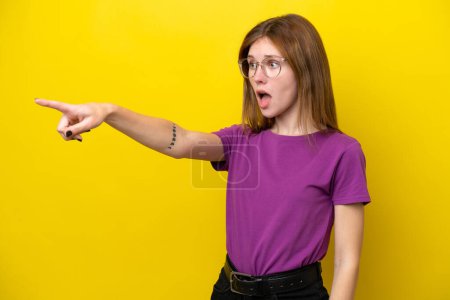 Téléchargez les photos : Jeune femme anglaise isolée sur fond jaune pointant du doigt - en image libre de droit