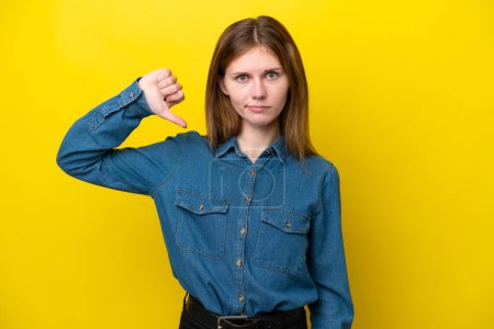 Photo for Young English woman isolated on yellow background showing thumb down with negative expression - Royalty Free Image
