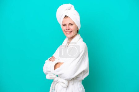 Photo for Young woman in a bathrobe isolated on blue background with arms crossed and looking forward - Royalty Free Image