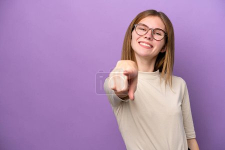 Téléchargez les photos : Jeune femme anglaise isolée sur fond violet pointant devant avec expression heureuse - en image libre de droit