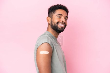Photo for Young Brazilian man wearing a band aid isolated on pink background with happy expression - Royalty Free Image