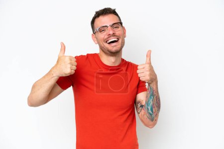 Photo for Young caucasian handsome man isolated on white background giving a thumbs up gesture - Royalty Free Image