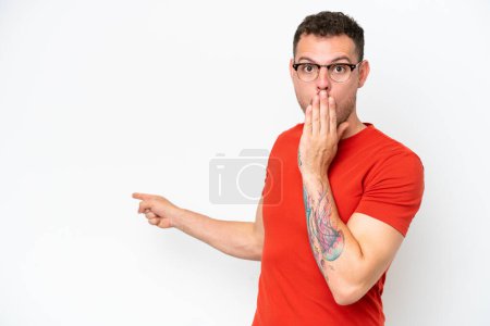 Photo for Young caucasian handsome man isolated on white background with surprise expression while pointing side - Royalty Free Image