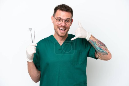 Photo for Young caucasian dentist man isolated on white background making phone gesture. Call me back sign - Royalty Free Image
