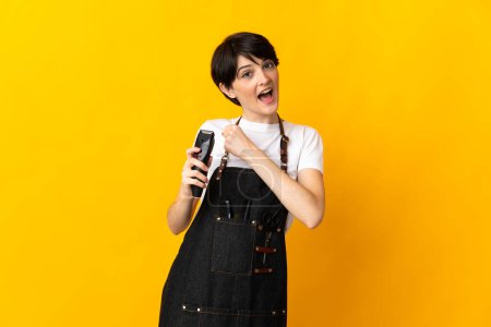 Photo for Hairdresser woman isolated on yellow background celebrating a victory - Royalty Free Image