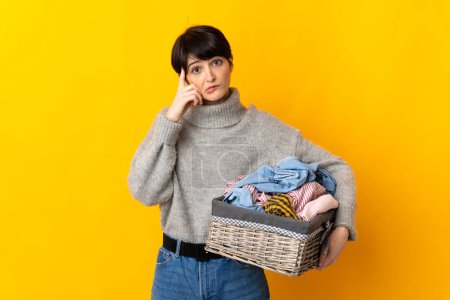 Photo for Woman with short hair holding a clothes basket thinking an idea - Royalty Free Image