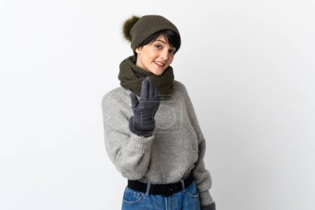Téléchargez les photos : Jeune fille avec chapeau d'hiver invitant à venir avec la main. Heureux que tu sois venu - en image libre de droit