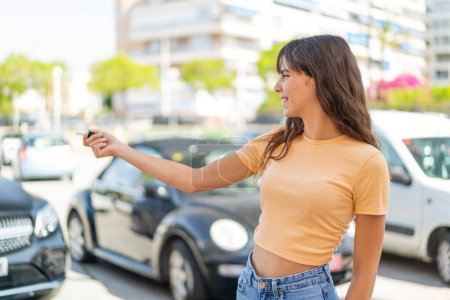 Téléchargez les photos : Jeune femme à l'extérieur tenant des clés de voiture - en image libre de droit