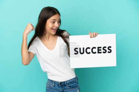 Photo for Young French woman isolated on blue background holding a placard with text SUCCESS and celebrating a victory - Royalty Free Image
