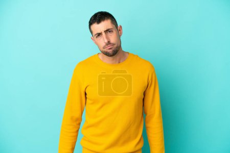 Photo for Young handsome caucasian man isolated on blue background with sad expression - Royalty Free Image