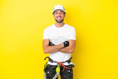 Téléchargez les photos : Jeune grimpeur isolé sur fond jaune gardant les bras croisés en position frontale - en image libre de droit