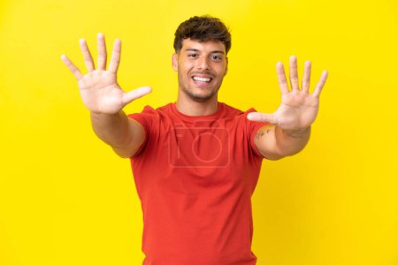 Téléchargez les photos : Jeune homme beau caucasien isolé sur fond jaune comptant dix avec les doigts - en image libre de droit