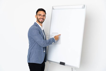 Photo for Young caucasian man isolated on white background giving a presentation on white board - Royalty Free Image