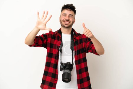 Téléchargez les photos : Jeune photographe caucasien isolé sur fond blanc comptant six avec les doigts - en image libre de droit