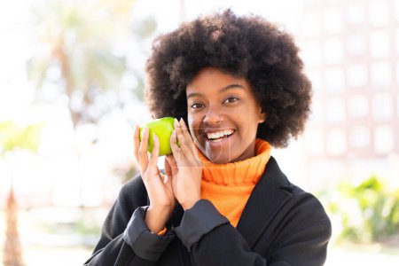 Foto de Chica afroamericana al aire libre sosteniendo una manzana - Imagen libre de derechos