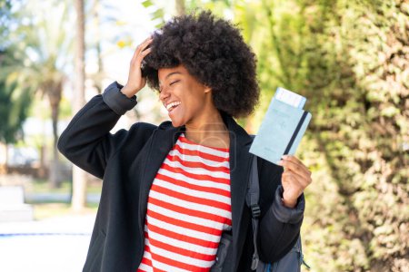 Foto de Chica afroamericana sosteniendo un pasaporte al aire libre se ha dado cuenta de algo y la intención de la solución - Imagen libre de derechos