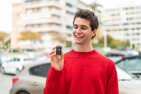 Photo for Young handsome man with car key with happy expression - Royalty Free Image