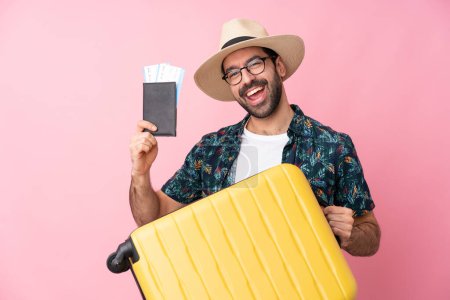 Photo for Young caucasian man over isolated background in vacation with suitcase and passport - Royalty Free Image