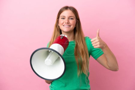 Photo for Young blonde woman isolated on pink background holding a megaphone with thumb up - Royalty Free Image