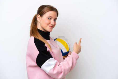 Téléchargez les photos : Young caucasian woman playing volleyball isolated on white background pointing back - en image libre de droit