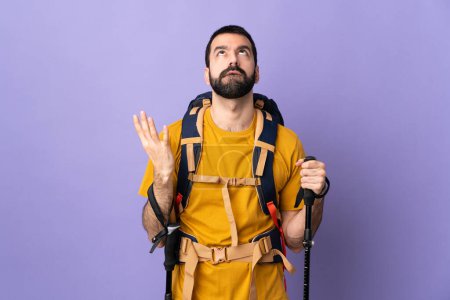 Téléchargez les photos : Blanc bel homme avec sac à dos et bâtons de trekking sur fond isolé stressé submergé - en image libre de droit