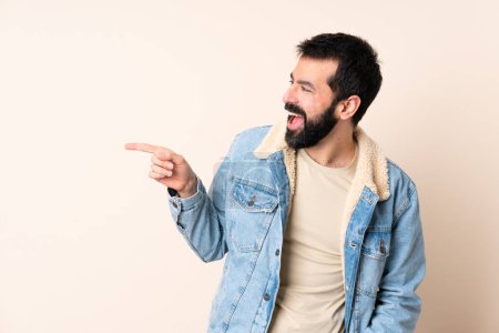 Téléchargez les photos : Homme caucasien avec barbe sur fond isolé pointant du doigt sur le côté et présentant un produit - en image libre de droit
