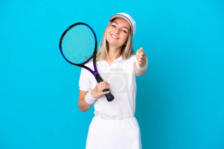 Photo for Young tennis player Romanian woman isolated on blue background shaking hands for closing a good deal - Royalty Free Image