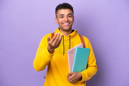 Photo for Young student Brazilian man isolated on purple background inviting to come with hand. Happy that you came - Royalty Free Image