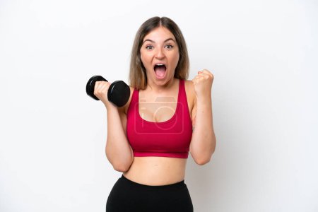 Photo for Young sport Rumanian woman making weightlifting isolated on white background celebrating a victory in winner position - Royalty Free Image