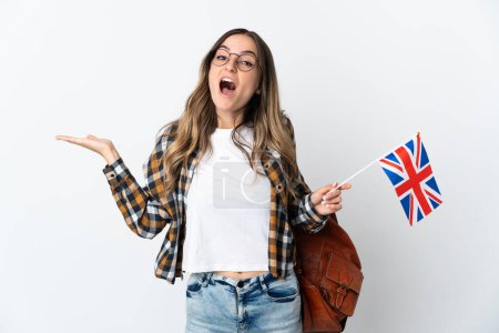 Junge Rumänin mit einer britischen Flagge auf weißem Hintergrund und schockiertem Gesichtsausdruck