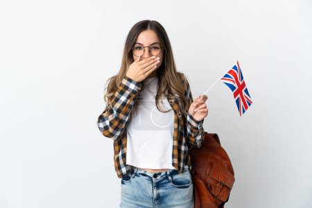 Mujer rumana joven sosteniendo una bandera del Reino Unido aislada sobre fondo blanco feliz y sonriente cubriendo la boca con la mano