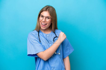 Téléchargez les photos : Jeune chirurgien médecin femme isolée sur fond bleu célébrant une victoire - en image libre de droit