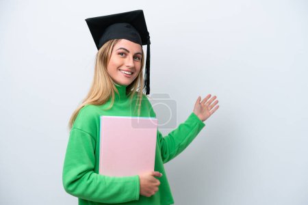 Photo for Young university graduate woman isolated on white background extending hands to the side for inviting to come - Royalty Free Image