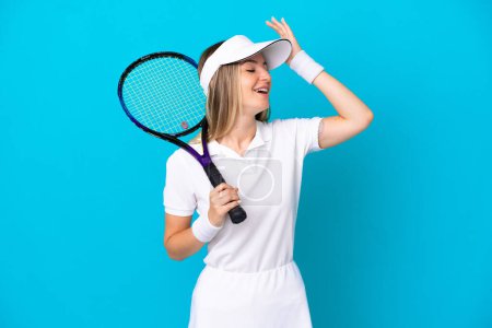 Photo for Young tennis player Romanian woman isolated on blue background smiling a lot - Royalty Free Image
