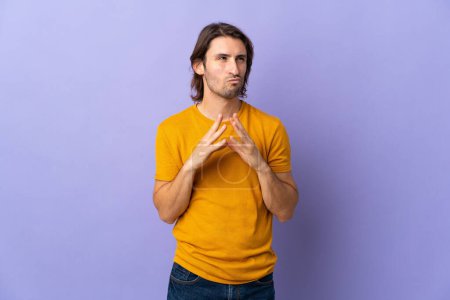 Young handsome man isolated on purple background scheming something