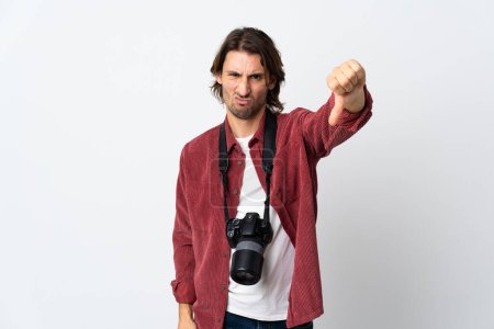Téléchargez les photos : Jeune photographe homme isolé sur fond blanc montrant pouce vers le bas avec expression négative - en image libre de droit