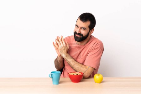Téléchargez les photos : Homme caucasien prendre le petit déjeuner dans une table comploter quelque chose
. - en image libre de droit