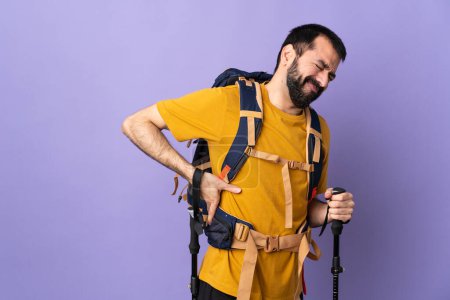 Photo for Caucasian handsome man with backpack and trekking poles over isolated background suffering from backache for having made an effort - Royalty Free Image