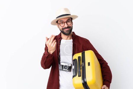 Photo for Traveler man man with beard holding a suitcase over isolated white background inviting to come with hand. Happy that you came - Royalty Free Image