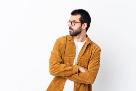 Foto de Hombre guapo caucásico con barba vistiendo una chaqueta de pana sobre retrato de fondo blanco aislado - Imagen libre de derechos