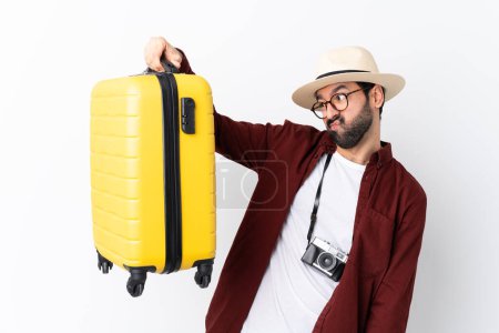 Foto de Hombre viajero con barba sosteniendo una maleta sobre un fondo blanco aislado - Imagen libre de derechos