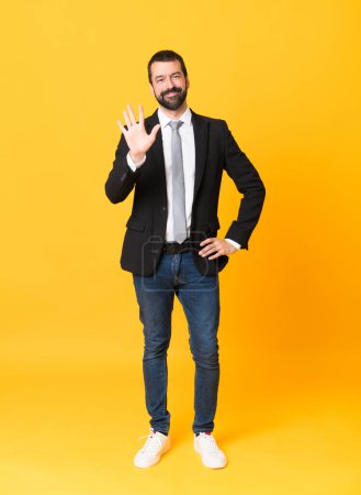 Photo for Full-length shot of business man over isolated yellow background counting five with fingers - Royalty Free Image