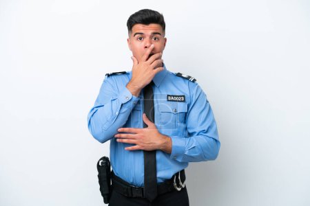 Foto de Joven policía caucásico hombre aislado sobre fondo blanco sorprendido y sorprendido mientras mira a la derecha - Imagen libre de derechos